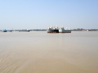 Obraz premium Container Ship in Ganga river. Marine Cargo Ships at Calcutta Port and Haldia Port for commercial freight transport from Kolkata to Bangladesh. Hooghly river West Bengal, India South Asia Pac May 2020