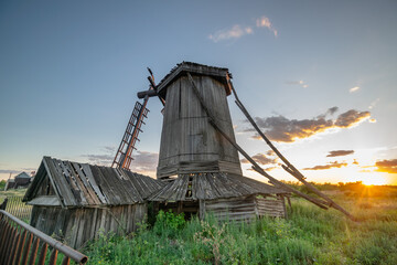 Old abandoned wooden wind mill, built in the 19th century in Samara region, Russia. Summer sunset landscape