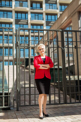 Obraz premium beautiful elderly woman with short hair and glasses in a red jacket