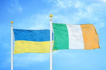 Ukraine and Ireland two flags on flagpoles and blue sky