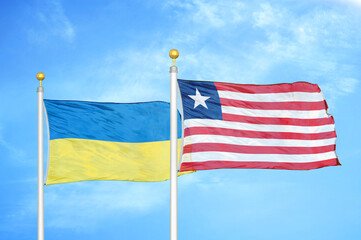 Ukraine and Liberia two flags on flagpoles and blue sky