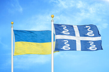 Ukraine and Martinique snake two flags on flagpoles and blue sky