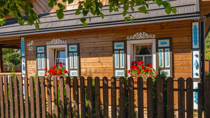 Traditional ornamented colorful open shutters of an old wooden Polish rural house in the village of...