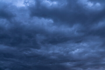 Naklejka na ściany i meble Beautiful dark stormy sky and blue dramatic clouds. Sky background.