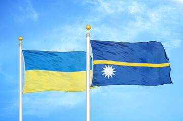 Ukraine and Nauru two flags on flagpoles and blue sky