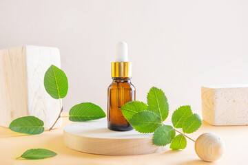 Cosmetic natural oil in a transparent bottle with a dispenser, wooden square and round. Wood,...