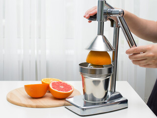 fresh orange juice squeezes the girl standing at the table