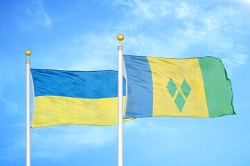 Ukraine and Saint Vincent and the Grenadines two flags on flagpoles and blue sky