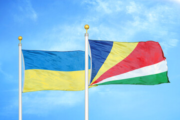 Ukraine and Seychelles two flags on flagpoles and blue sky