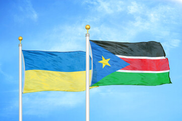 Ukraine and South Sudan two flags on flagpoles and blue sky
