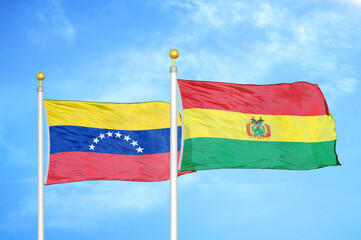 Venezuela and Bolivia two flags on flagpoles and blue sky