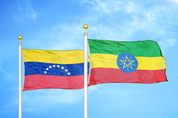 Venezuela and Ethiopia two flags on flagpoles and blue sky