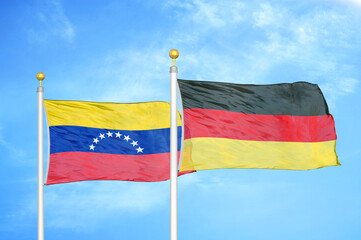 Venezuela and Germany two flags on flagpoles and blue sky