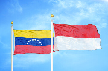 Venezuela and Indonesia two flags on flagpoles and blue sky