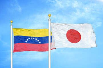 Venezuela and Japan two flags on flagpoles and blue sky