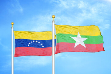 Venezuela and Myanmar two flags on flagpoles and blue sky