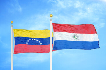Venezuela and Paraguay two flags on flagpoles and blue sky
