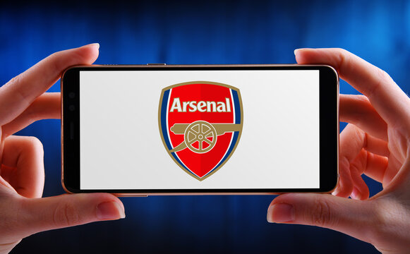 Hand holding smartphone displaying logo of Arsenal FC