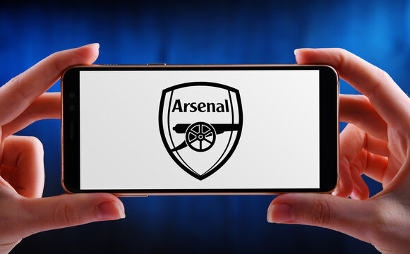 Hand holding smartphone displaying logo of Arsenal FC