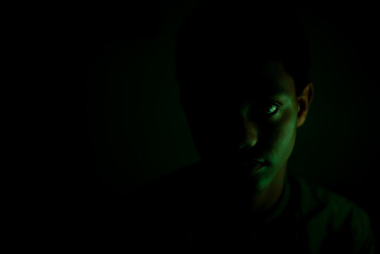 Portrait of teenager staring in dark room