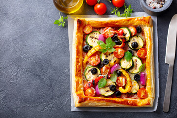 Puff pastry pizza with grilled vegetables. Grey background. Copy space. Top view.