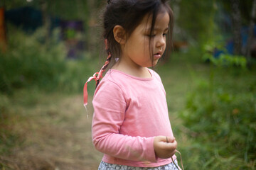 Girl 4 years old in the forest. Little girl of Asian appearance