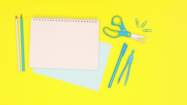 Blue office and school stationery moving around open notebook. Stop motion 