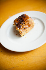 Bitten chocolate croissant on a white plate