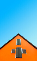 Orange house against blue sky. House with orange walls minimalist. German architecture