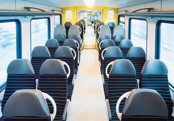 Train interior with empty chairs. German passenger train carriage in motion