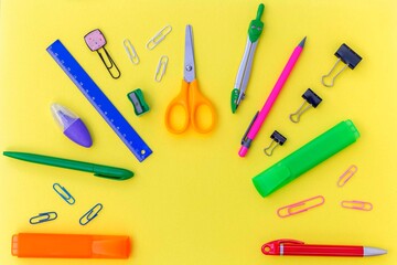 Empty copy space for your text in the semicircle frame of school supplies as pens, pencils, ruler, scissors, sharpener, marker, clips, divider. Creative flat lay with stationary.