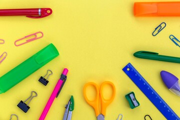 Creative flat lay with empty copy space for your text in the semicircle frame of school supplies as pens, pencils, ruler, scissors, sharpener, marker.