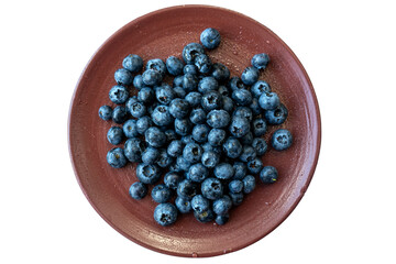 Fresh blackberries or blueberries in a brown clay ceramic plate photographed from above. Close up of fresh healthy summer berries. 
