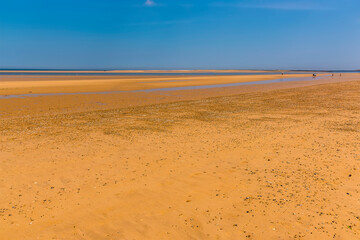 A view across the wide sandy expanse of Brancaster Beach, Norfolk, UK