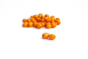 Handful of useful medicinal sea buckthorn berries on a white isolated background, focus on two sea buckthorn berries.
