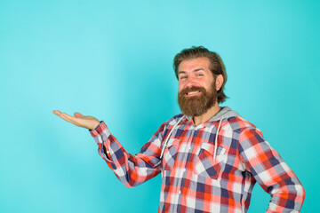 Smiling bearded man shows something. Advertising content. Copy space for your text. Look attention....