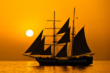 Obraz na płótnie Canvas sailing ship at sunset