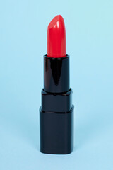 Fashion red lip stick, make up. Isolated on blue background.