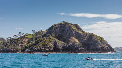 Fototapeta na wymiar Rocky coastline and boats in Bay of Islands, New Zealand
