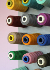 Spools of colored thread on a vertical stand. Sewing studio. 