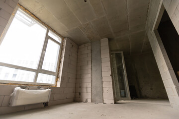 A new unfinished apartment room with the bare brick walls without decoration.