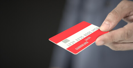Man gives plastic bank card with printed flag of Austria. Fictional numbers