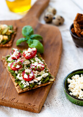 Healthy toast with avocado, greek cheese and cherry tomatoes with basil. Close up. Selective focus.