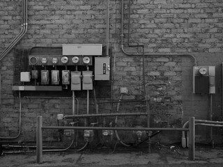 Utility pipes and service panels on a wall in an alley