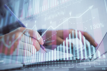 Double exposure of businesswoman hands typing on computer and forex graph hologram drawing. Financial analysis concept.