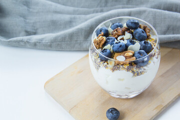 Healthy blueberry and walnut parfait in a glass on a white background