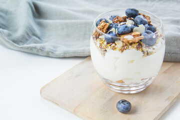 Healthy blueberry and walnut parfait in a glass on a white background