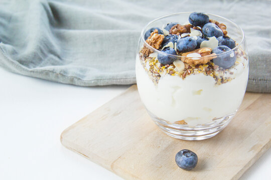 Healthy blueberry and walnut parfait in a glass on a white background