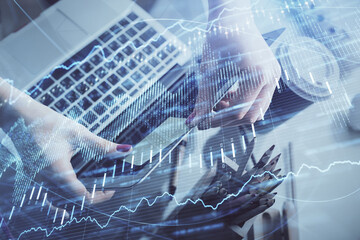 Double exposure of businesswoman hands typing on computer and financial graph hologram drawing. Stock market analysis concept.