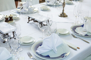 Elegant dinner table setting with china, glasses and napkins